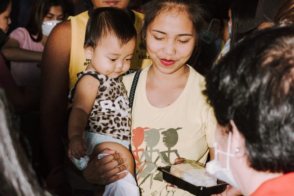 A Taal evacuee receives a packed meal from BAVI