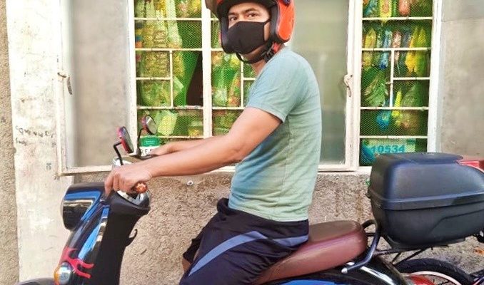 Bernard Bobos roke his e-bike to distribute food support to his fellow Chooks-to-Go crew members