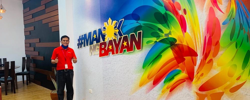 Isabela Business Center head Ronald Nolasco posed in front of a colorful mural at their renovated office